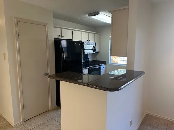 a kitchen with a refrigerator and microwave