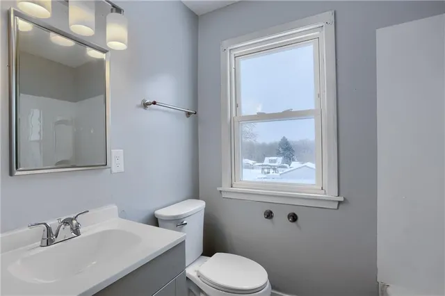 a bathroom with a toilet a sink and mirror
