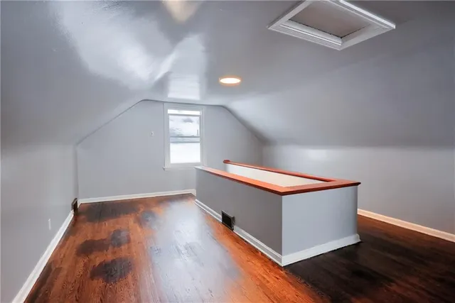 a room with wooden floor and potted plant
