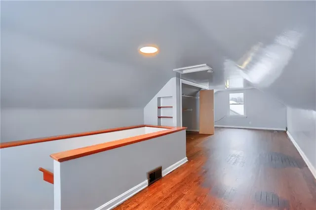 a hallway with stairs and wooden floor