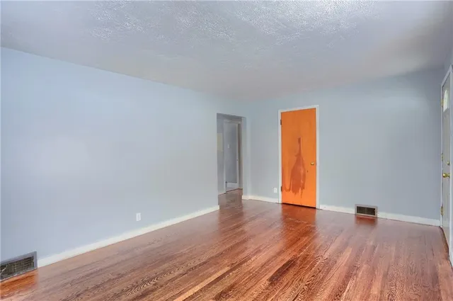 a view of an empty room and wooden floor