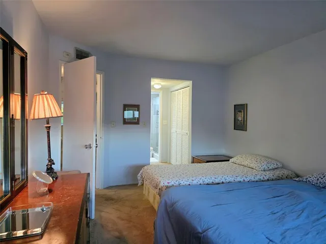 a bedroom with a bed and dresser with mirror