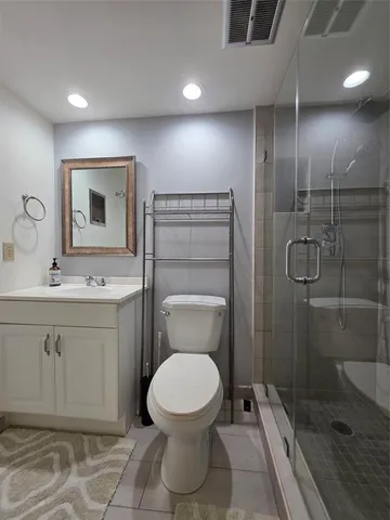 a bathroom with a toilet sink vanity and granite