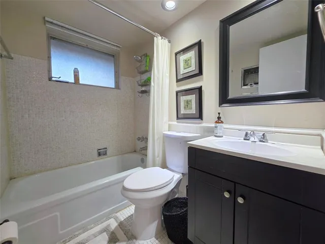 a bathroom with a sink toilet vanity and tub
