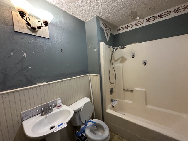 548 Spring River Drive Martindale, TX 78655 - Photo 15 of 17 Full bathroom with a wainscoted wall, bathtub / shower combination, and a textured ceiling