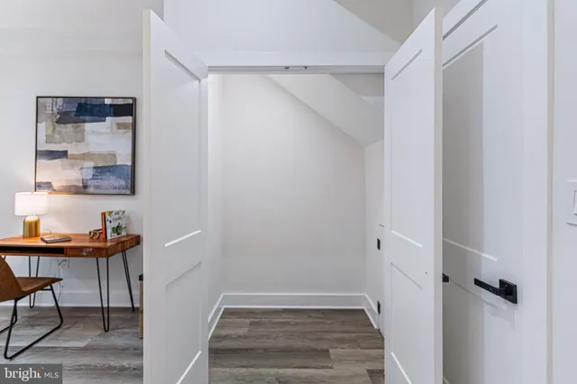 a view of a hallway to a livingroom with furniture and wooden floor