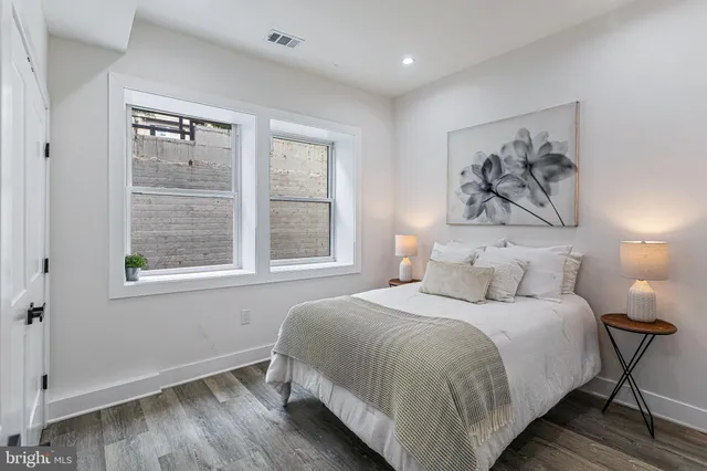 a bedroom with a bed and a painting on the wall