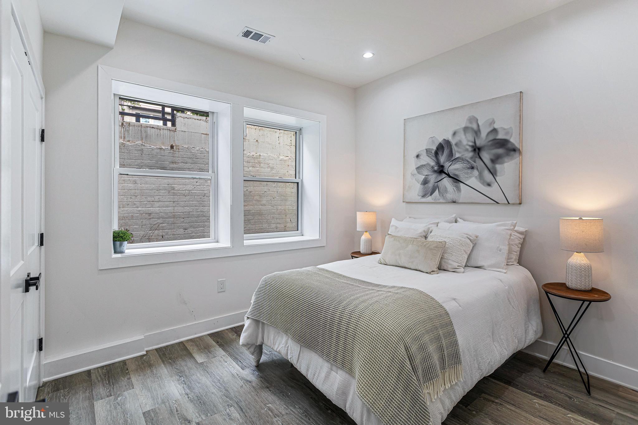 1107 Queen Street Northeast, Unit 2 Washington, DC 20002 - Photo 16 of 26 a bedroom with a bed and a painting on the wall