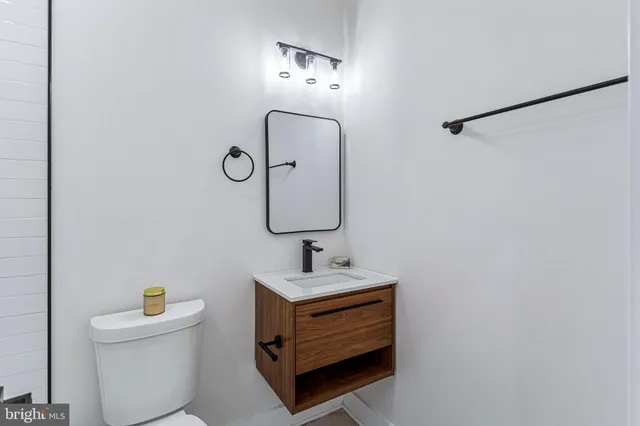 a bathroom with a sink toilet and mirror