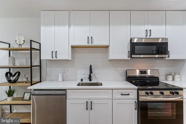a kitchen with stainless steel appliances a stove a sink and a microwave
