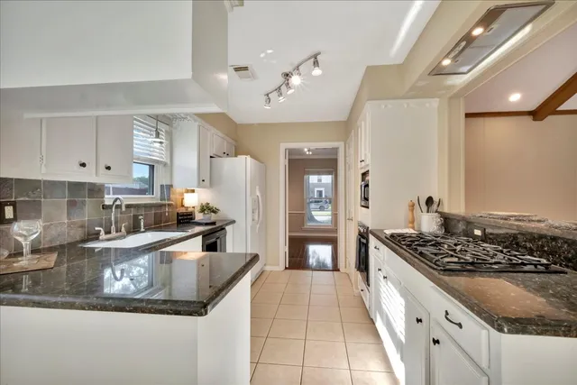 a open kitchen with stainless steel appliances granite countertop a sink stove and refrigerator