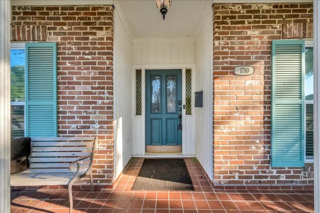 a view of a hallway with a livingroom and a chandelier