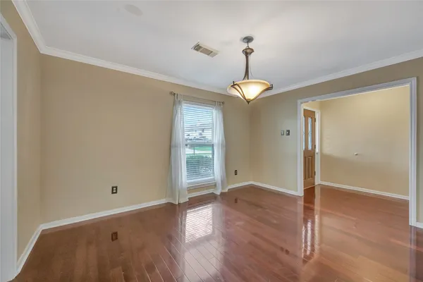 a view of empty room with wooden floor