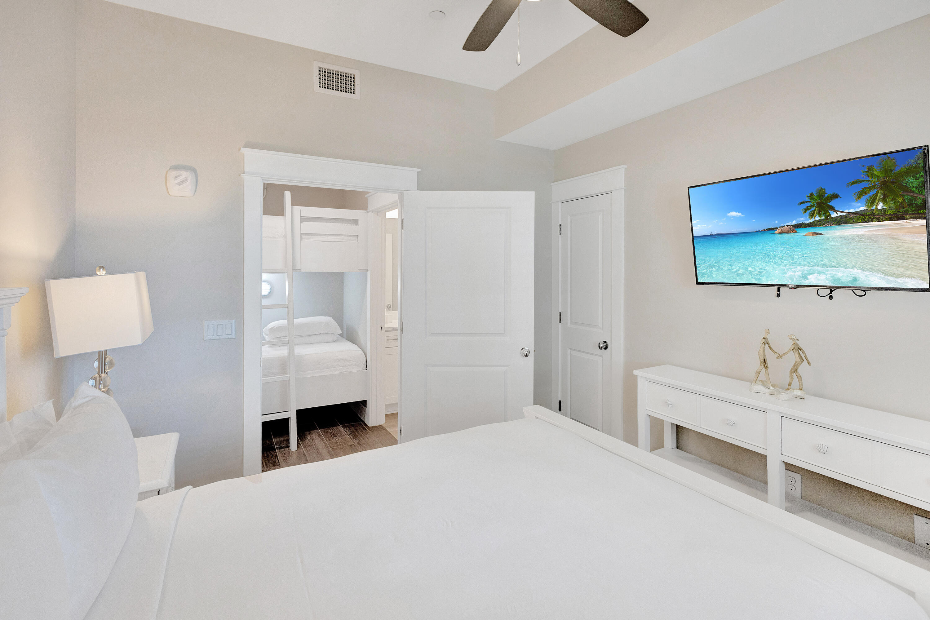 204 Henderson Resort Way, Unit 3104 Destin, FL 32541 - Photo 16 of 37 a bedroom with a bed and a flat tv screen on dresser