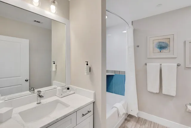a bathroom with a tub sink and mirror