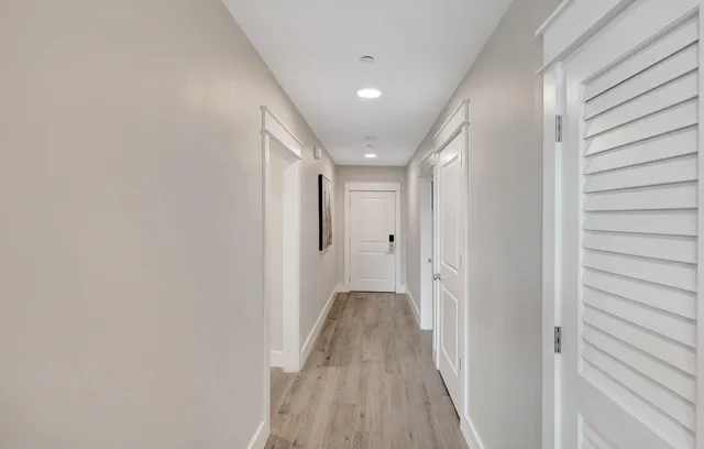 a view of a hallway with wooden floor