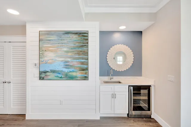 an empty room with wooden floor mirror and window