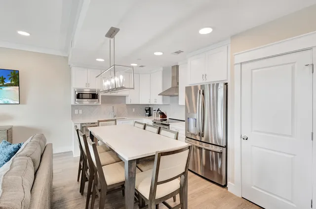 a kitchen with kitchen island a appliances dining table and chairs