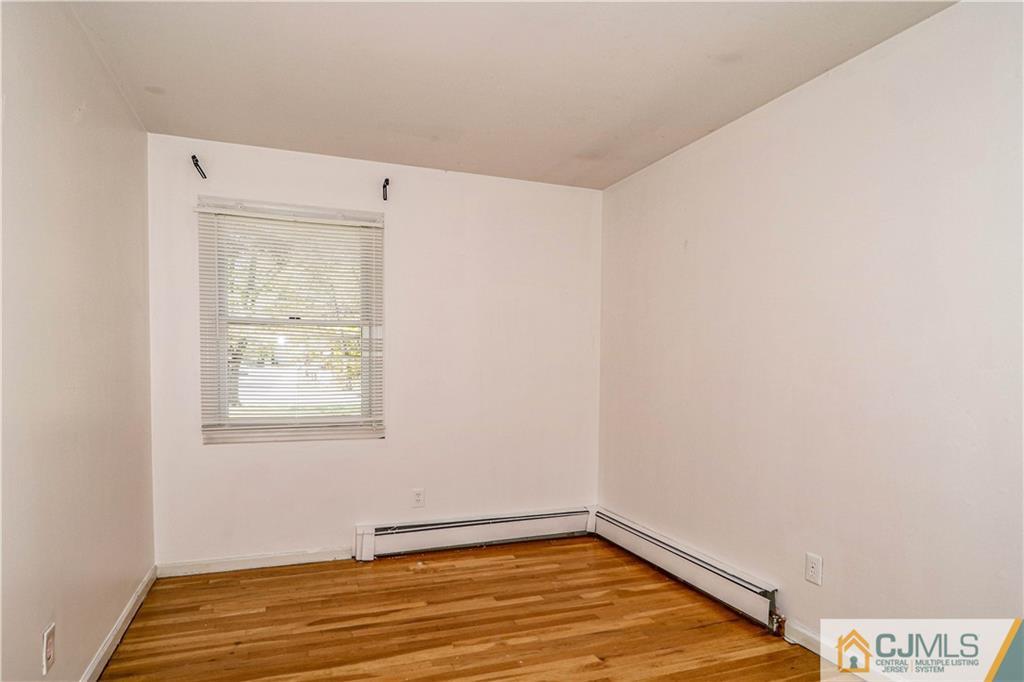 860 Grove Avenue Edison, NJ 08820 - Photo 11 of 22 a view of an empty room with wooden floor and a window