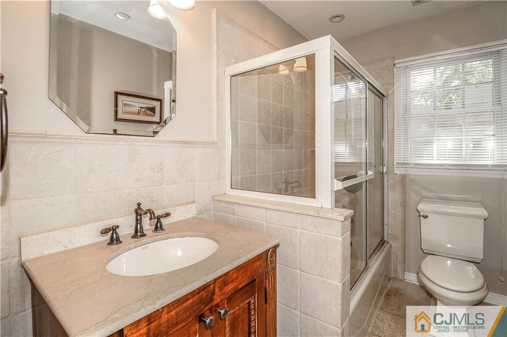 860 Grove Avenue Edison, NJ 08820 - Photo 12 of 22 a bathroom with a sink a toilet and a mirror