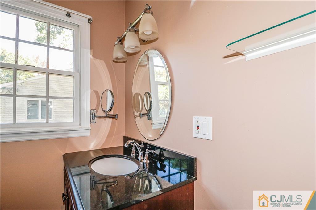 860 Grove Avenue Edison, NJ 08820 - Photo 15 of 22 a bathroom with a granite countertop toilet a mirror and a window