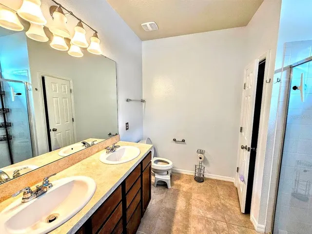 a spacious bathroom with a granite countertop sink and a mirror