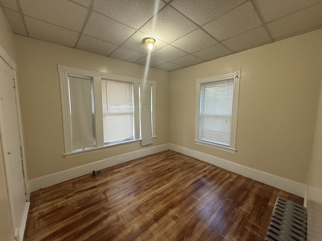 32 Manchester Street, Unit 1 Lowell, MA 01852 - Photo 2 of 8 a view of an empty room with wooden floor and a window