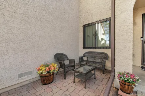 a front view of a house with chairs and a potted plant
