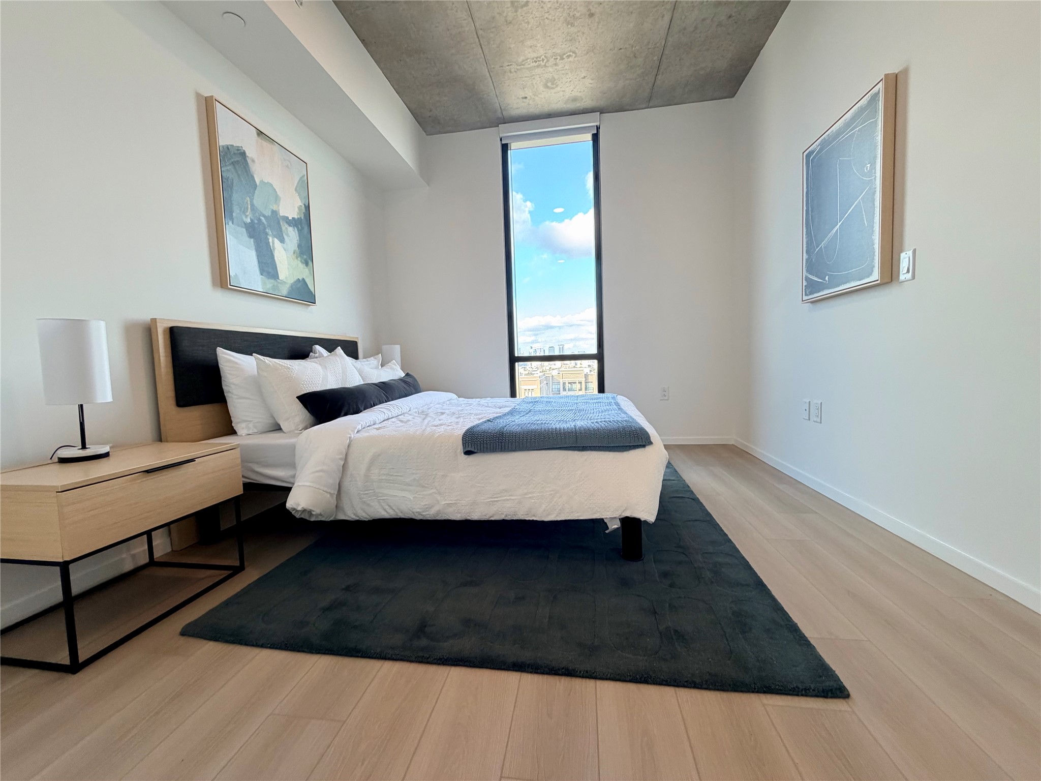 5501 La Branch Street, Unit 2108 Houston, TX 77004 - Photo 1 of 12 a bedroom with a bed wooden floor and lamp