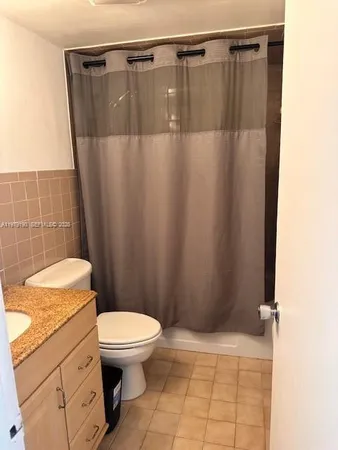 a bathroom with a granite countertop sink toilet and a mirror