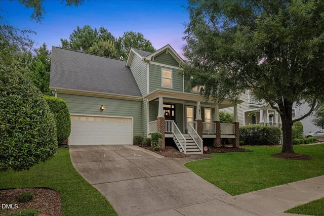 a front view of a house with a garden and trees