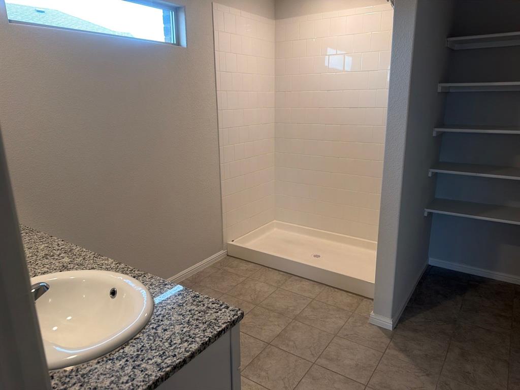 721 Durango Lane Cleburne, TX 76033 - Photo 10 of 25 a bathroom with a granite countertop sink and mirror with bathtub