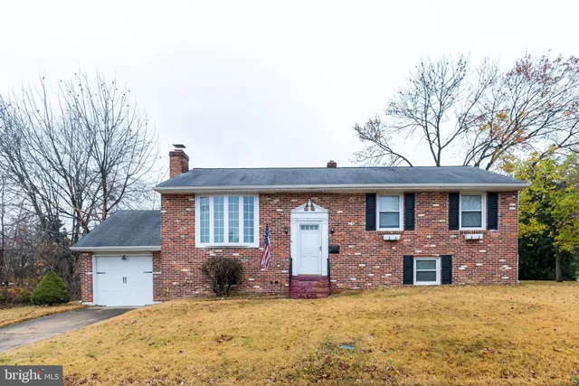 a front view of a house with yard and tress