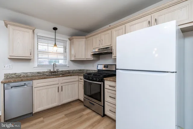 a kitchen with stainless steel appliances granite countertop a refrigerator sink and stove
