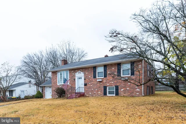 a front view of a house with a yard covered in snow
