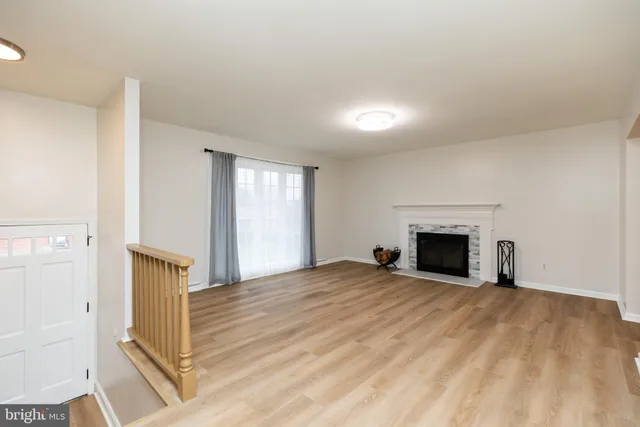 a view of empty room with wooden floor and fireplace