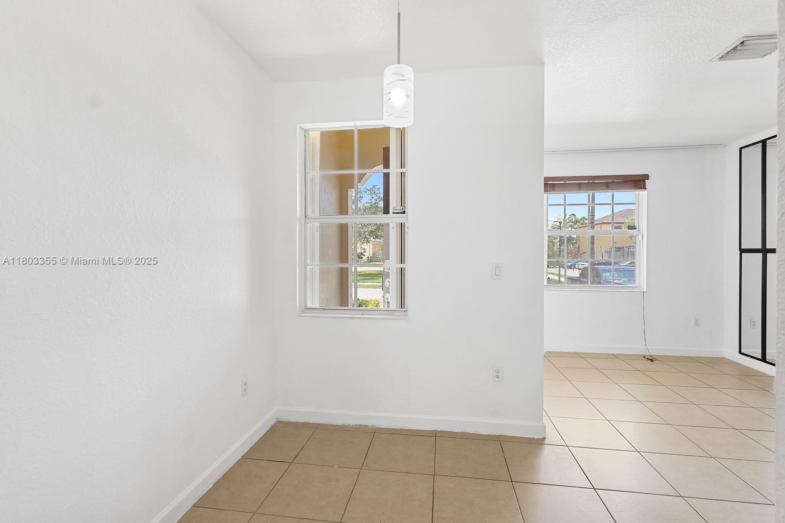 9153 Southwest 227th Street, Unit 3 Cutler Bay, FL 33190 - Photo 11 of 32 an empty room with windows