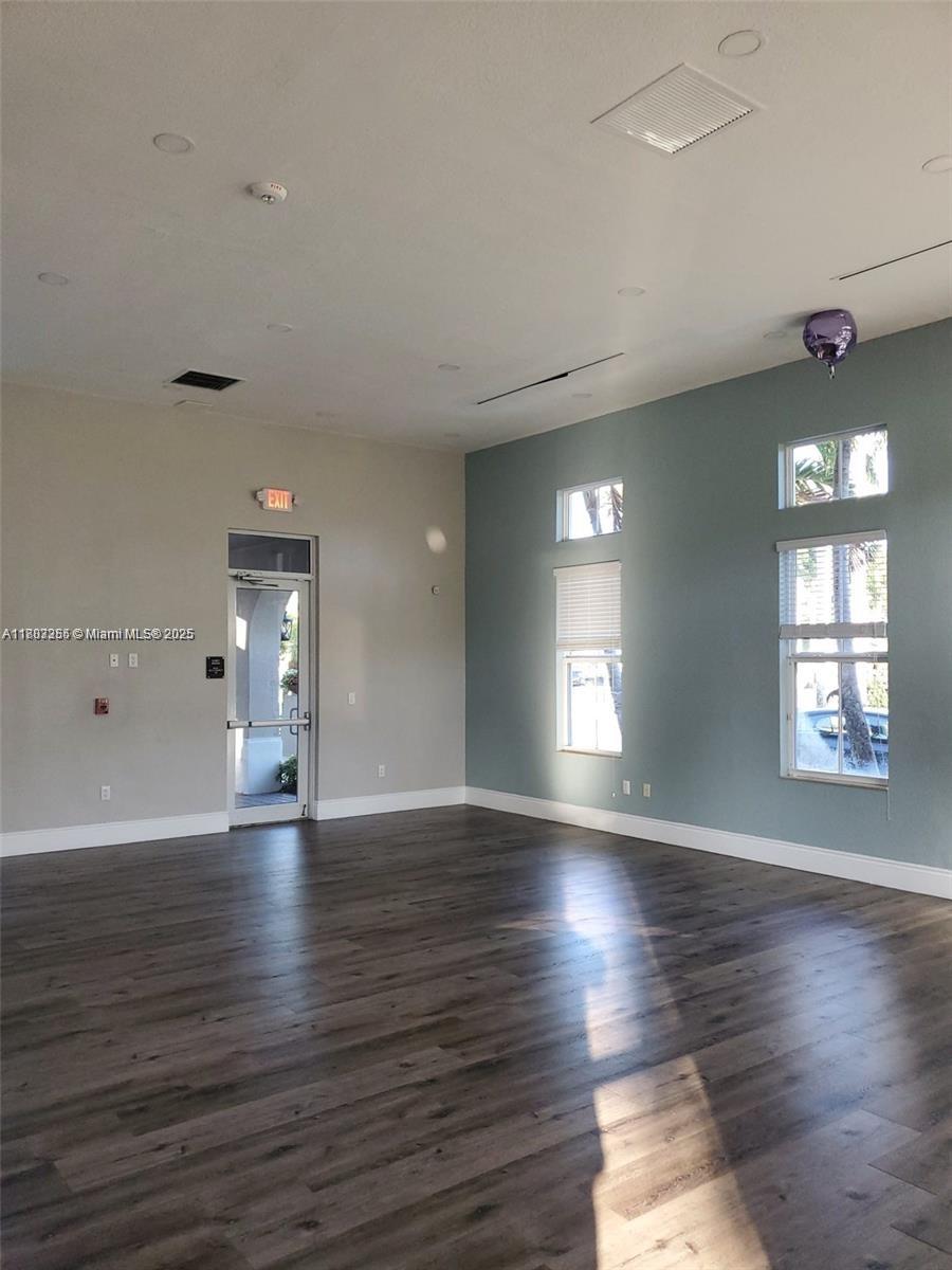 9153 Southwest 227th Street, Unit 3 Cutler Bay, FL 33190 - Photo 29 of 32 an empty room with wooden floor and windows