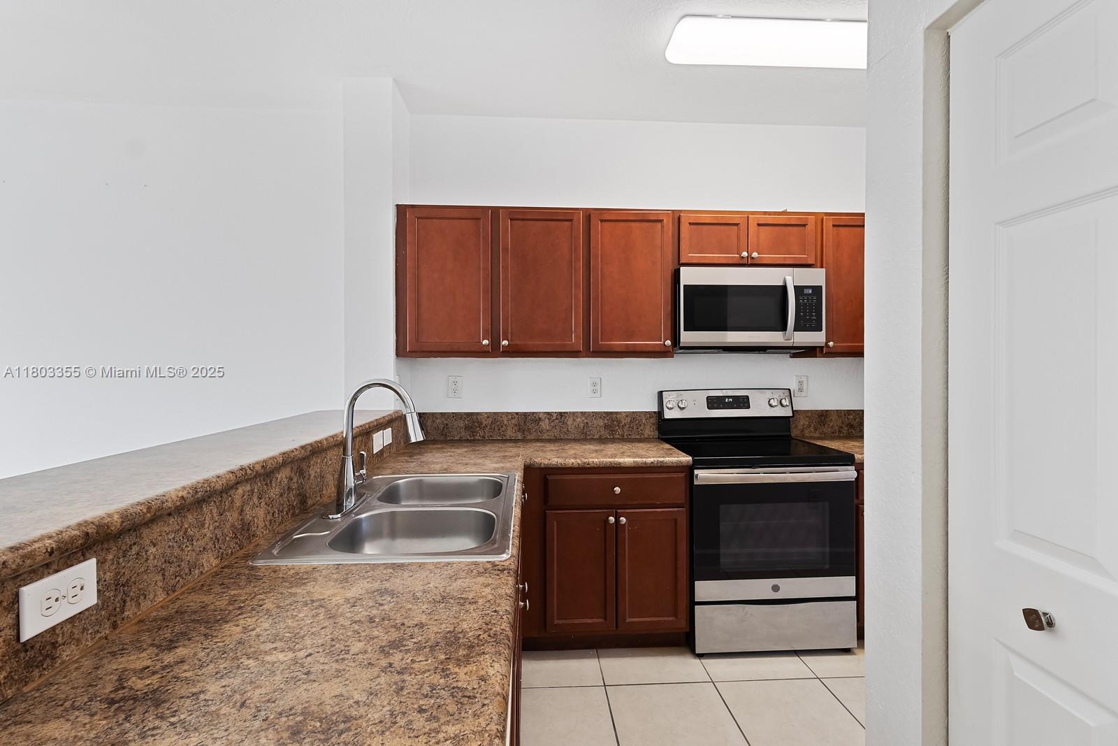 9153 Southwest 227th Street, Unit 3 Cutler Bay, FL 33190 - Photo 3 of 32 a kitchen with a sink and a stove top oven