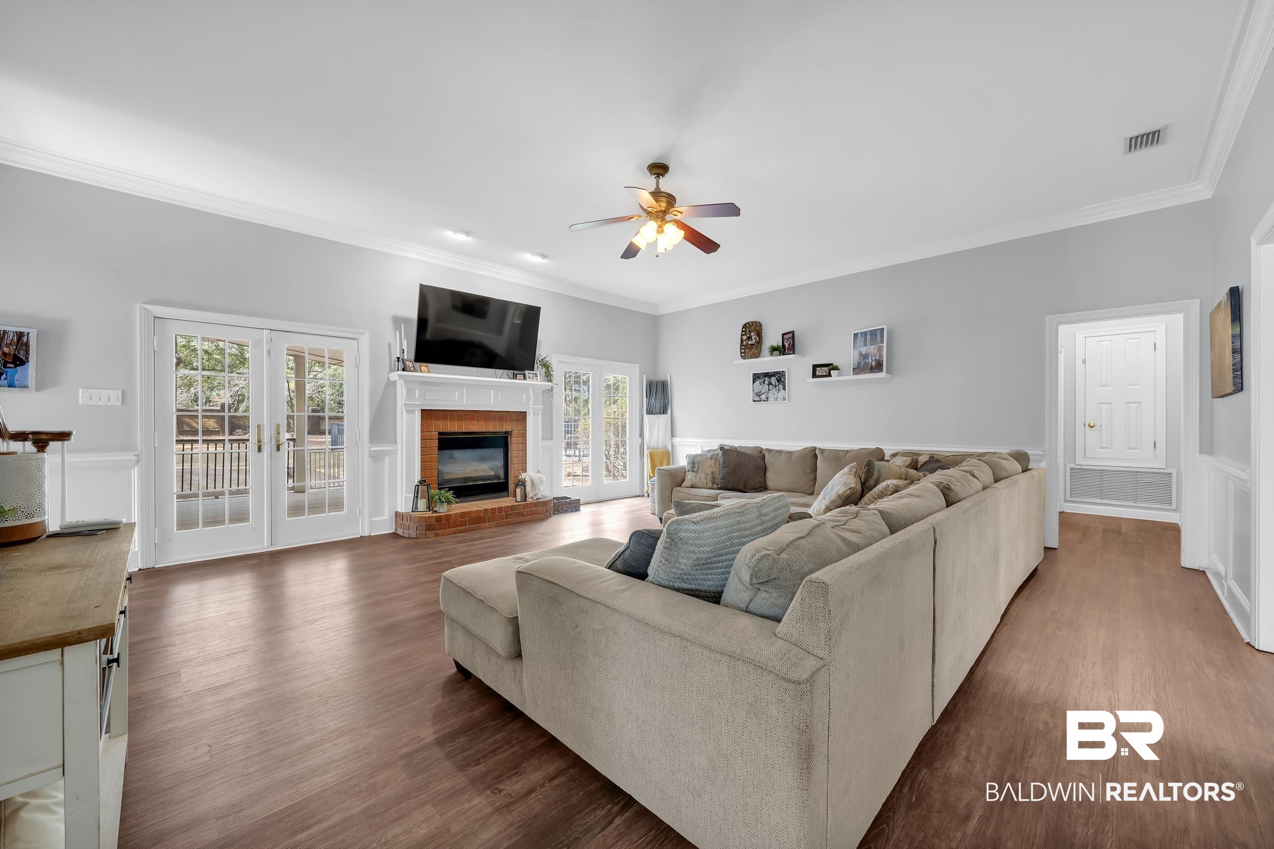 2858 Postoak Circle Mobile, AL 36693 - Photo 13 of 32 Living room with crown molding, dark wood-style flooring, wainscoting, french doors, and ceiling fan