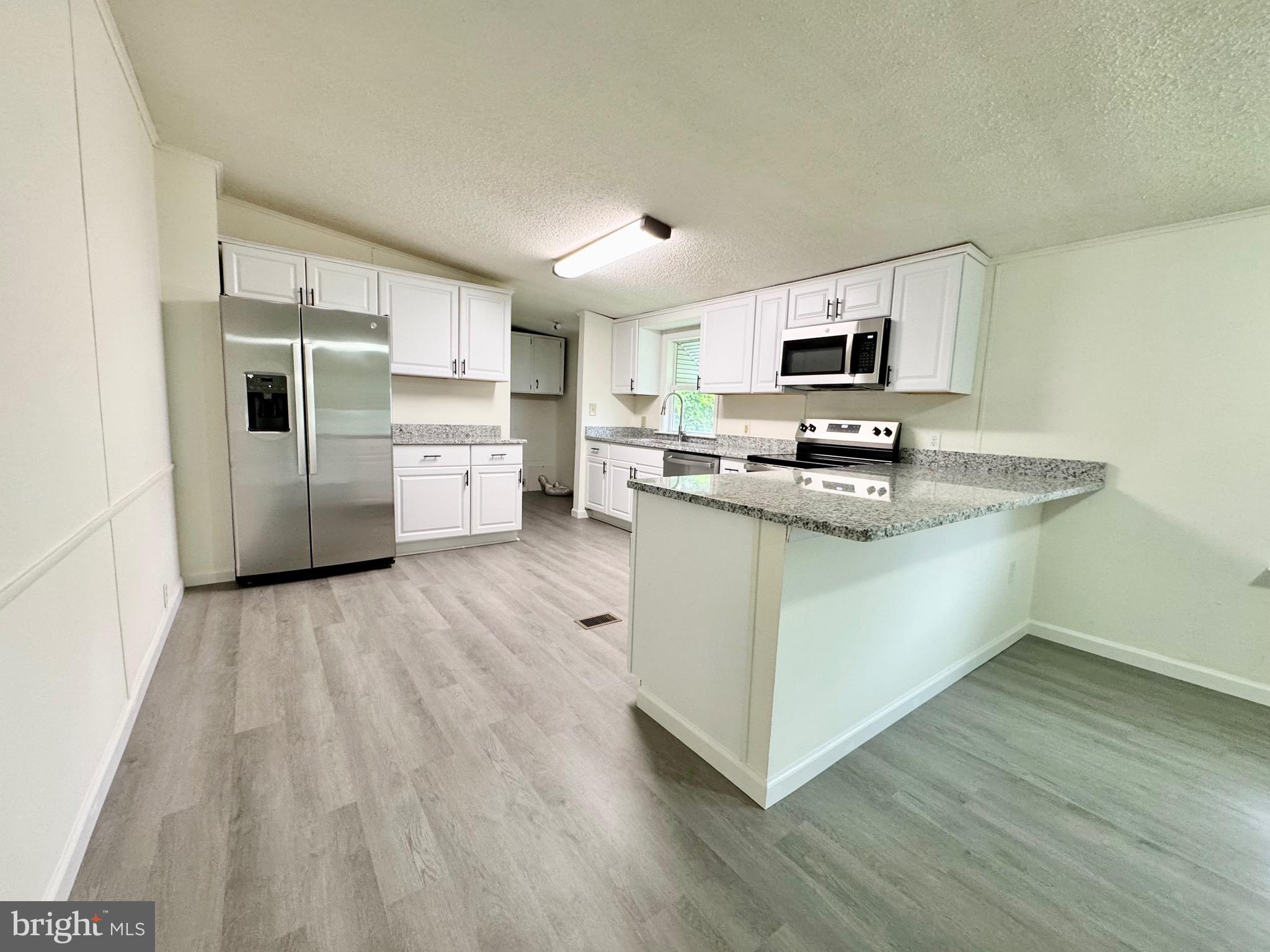 4 Welch Drive Dover, DE 19901 - Photo 15 of 22 a kitchen with a sink a counter top space stainless steel appliances and cabinets