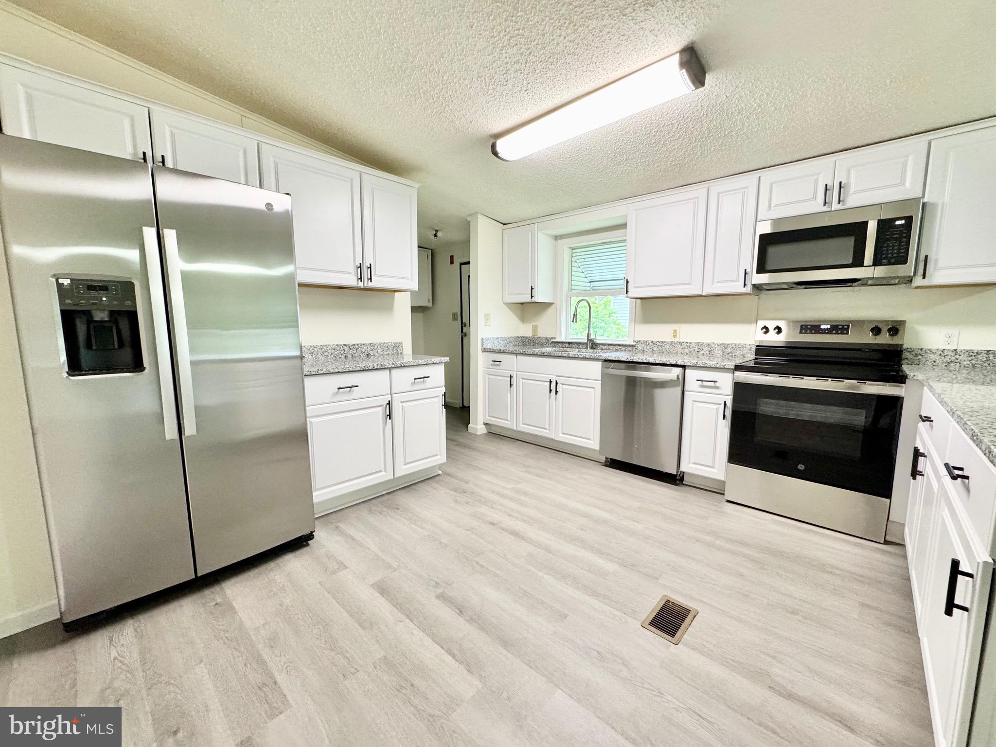 4 Welch Drive Dover, DE 19901 - Photo 16 of 22 a kitchen with stainless steel appliances granite countertop a refrigerator a stove top oven a sink and dishwasher