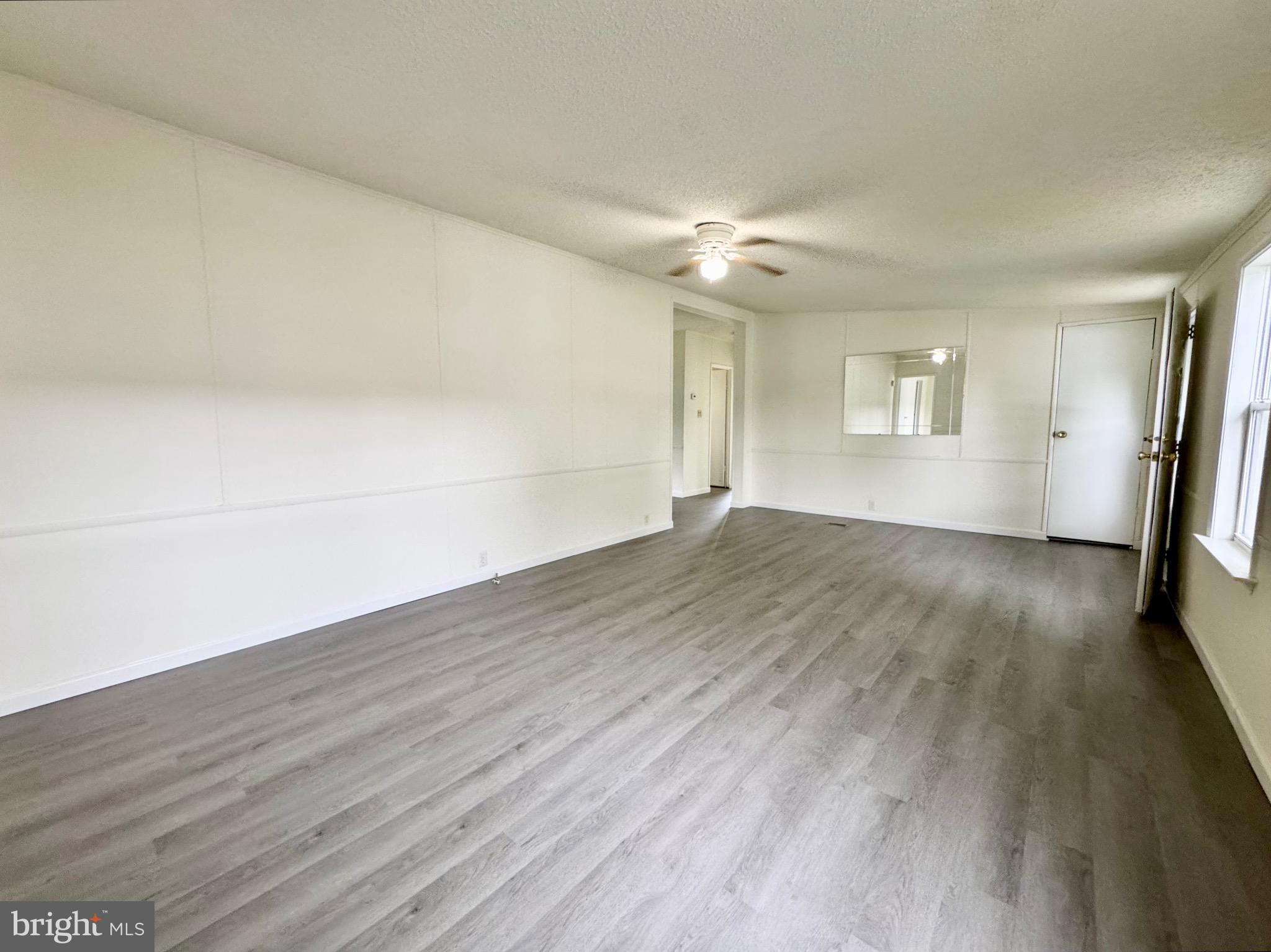 4 Welch Drive Dover, DE 19901 - Photo 3 of 22 an empty room with wooden floor and windows