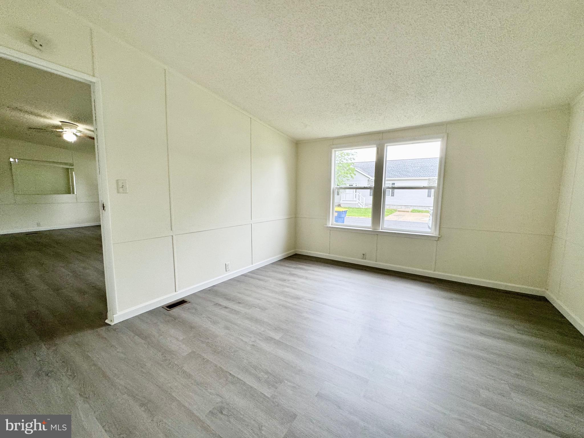 4 Welch Drive Dover, DE 19901 - Photo 7 of 22 an empty room with wooden floor and windows