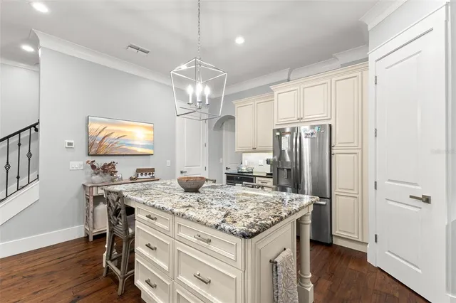 a kitchen with kitchen island granite countertop a sink appliances cabinets and wooden floor