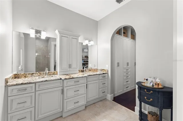 a bathroom with a double vanity sink and mirror with shower