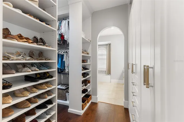 a view of walk in closet with clothes and shoes