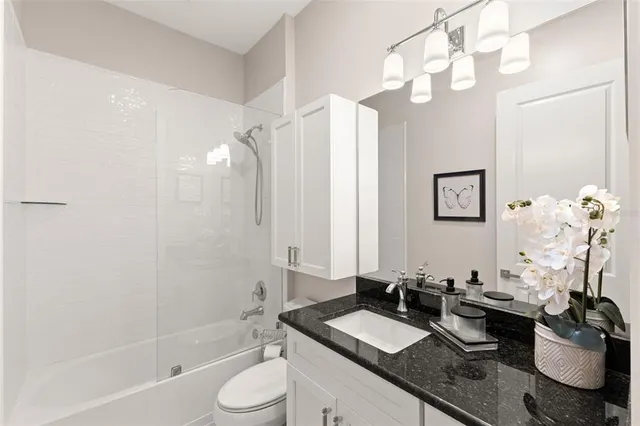 a bathroom with a granite countertop sink toilet and shower