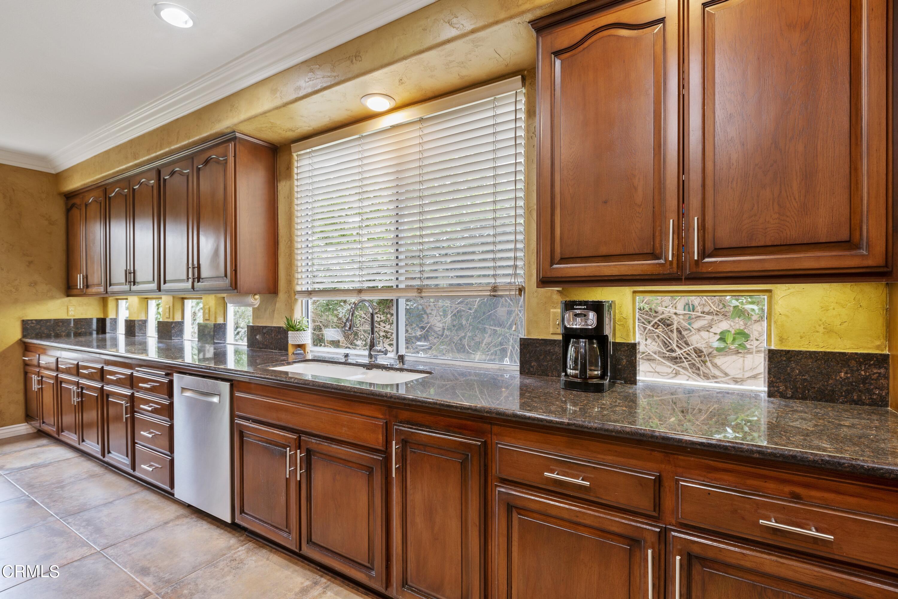 11774 Pinedale Road Moorpark, CA 93021 - Photo 18 of 37 a kitchen with stainless steel appliances granite countertop wooden cabinets a sink and dishwasher