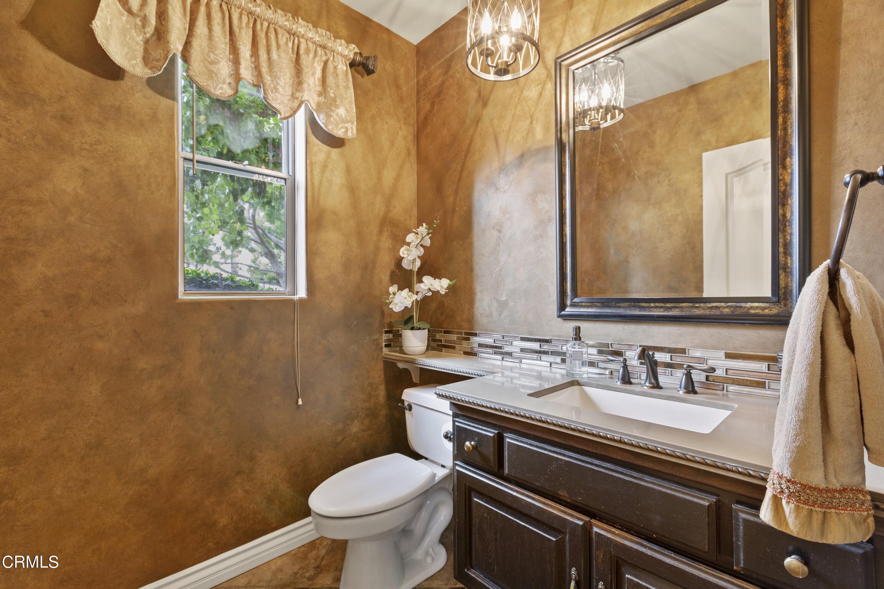 11774 Pinedale Road Moorpark, CA 93021 - Photo 30 of 37 a bathroom with a sink a toilet and a mirror